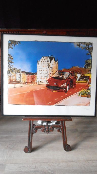 Stadsgezicht met een rode auto en gebouwen onder een heldere blauwe lucht.